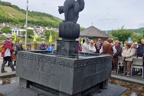 Brunnen schwarzer Kater mit der Gruppe im Hintergrund