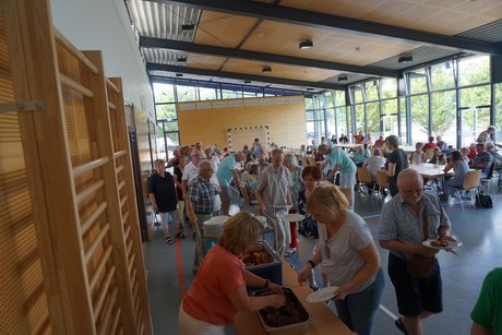 Eine lange Schlange steht an der Essensausgabe an, um ihr Essen von Elke oder Rüdiger Röth zu bekommen.