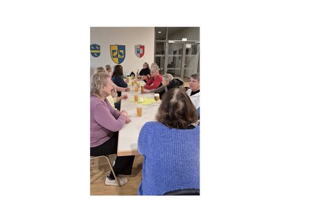 Stammtisch Liederbachhalle mehrere Personen sitzen an einer langen tafel und unterhalten sich