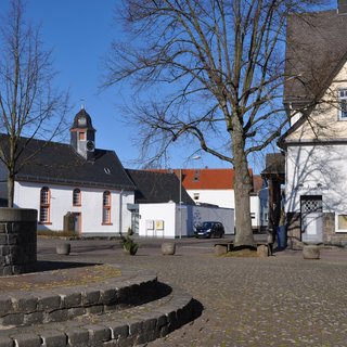 Dorfplatz mit Brunnen, Kirche und Alte Schule