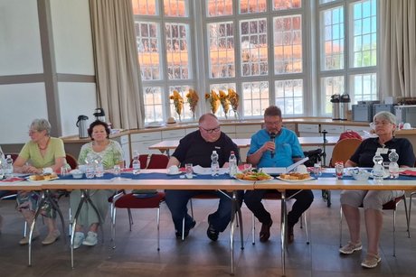 Die G&auml;ste sitzen an der Stirnseite der Tisch-Reihe.