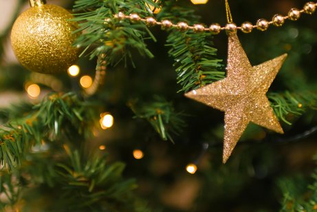 Ausschnitt eines geschm&uuml;ckten Weihnachtsbaums mit goldenen Kugeln und Sternen