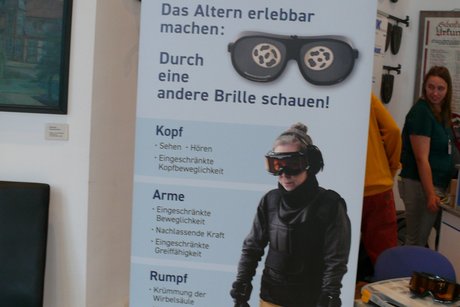 Rollup mit Abbildung des Alterssimulationsanzuges