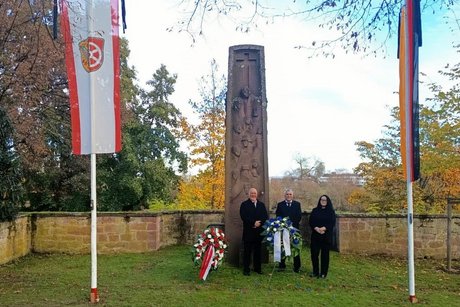Das Vorstandsteam des VdK-Ortsverbandes vor dem Ehrenmal, links der Kranz der Stadt Seligenstadt
