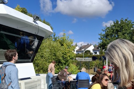 Blick vom Oberdeck nach Maintal, man sieht das Stadtschild. Im Vordergrund sind Fahrg&auml;ste, links die Br&uuml;cke.