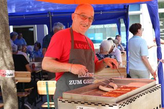 Manfred Palmrich vom Vorstand steht am Gasgrill und grillt Würstchen