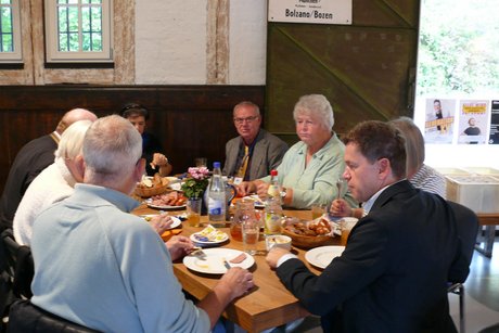 Es schmeckt Es sind verschiedene Gäste zu sehen. die essen und trinken.
