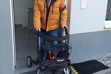 Das Bild zeigt Markus Monteiro beim Verlassen der Physiotherapie mit dem Rollator &uuml;ber eine Rampe