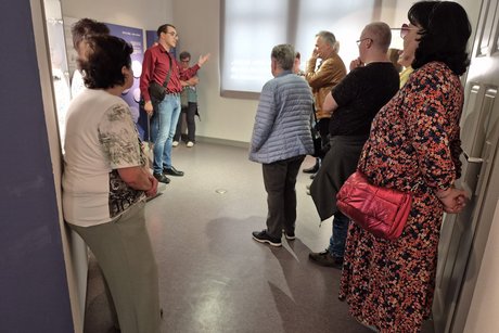 Die Gäste hören dem Museumsleiter bei seinen Erklärungen zu.