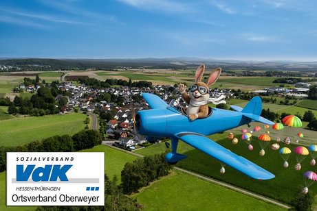 Auf dem Bild ist ein lustiger Osterhase in einem Flugzeug &uuml;ber dem Ort Oberweyer zu sehen. Aus dem Flugzeug fallen bunte Ostereier an Fallschirmen herunter.