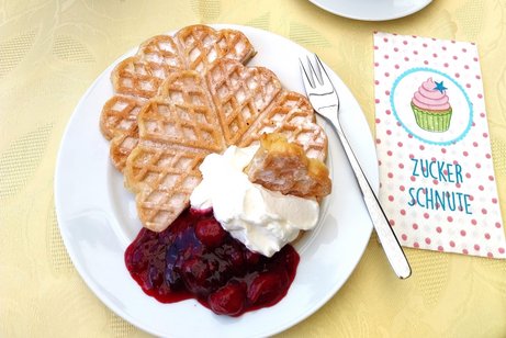 Teller mit Waffel, Sahne, Kirschen