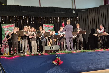 Eine Gruppe Jugendliche singt mit Instrumenten f&uuml;r das Publikum