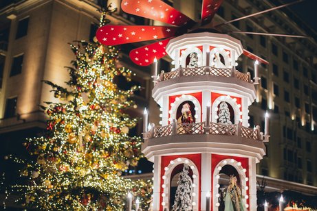 Weihnachtsmarkt mit geschm&uuml;cktem Baum und Weihnachtspyramide