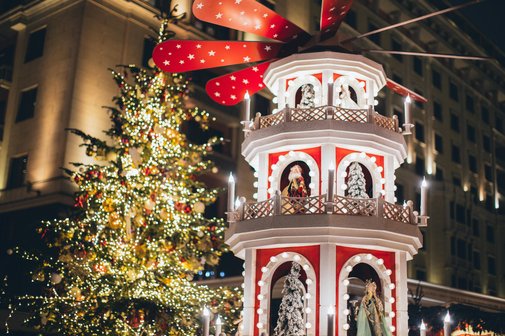 Weihnachtsmarkt mit geschm&uuml;cktem Baum und Weihnachtspyramide