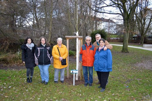 Frau Wissenbach (Stadtverwaltung) sowie die Mitglieder des VdK Urberach Sonja und Renate Grohe, Horst Frank, Knut und Anita Poschmann (Vorsitzende), (v.l.n.r.) , am Baum mit dem gerade aufgestellten Schild