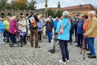 VdK-Mitglieder bekommen vor der Residenz etwas vom Reiseleiter erklärt