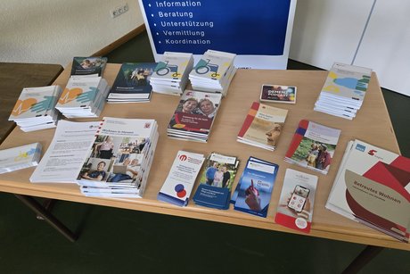 Auf einem Tisch liegen Informationsbrosch&uuml;ren zu Pflege Themen