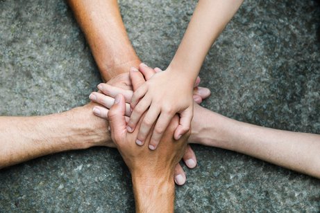 F&uuml;nf Personen legen jeweils eine Hand aufeinander, so dass ein Kreis bzw. ein Stern entsteht