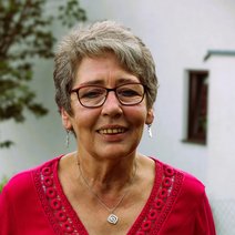 Passfoto Frau kurze schwarz grau melierte Haare rote Brille l&auml;chelt