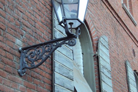 Backsteinhaus historisch mit Au&szlig;enlampe_Fensterl&auml;den am Fenster bds.