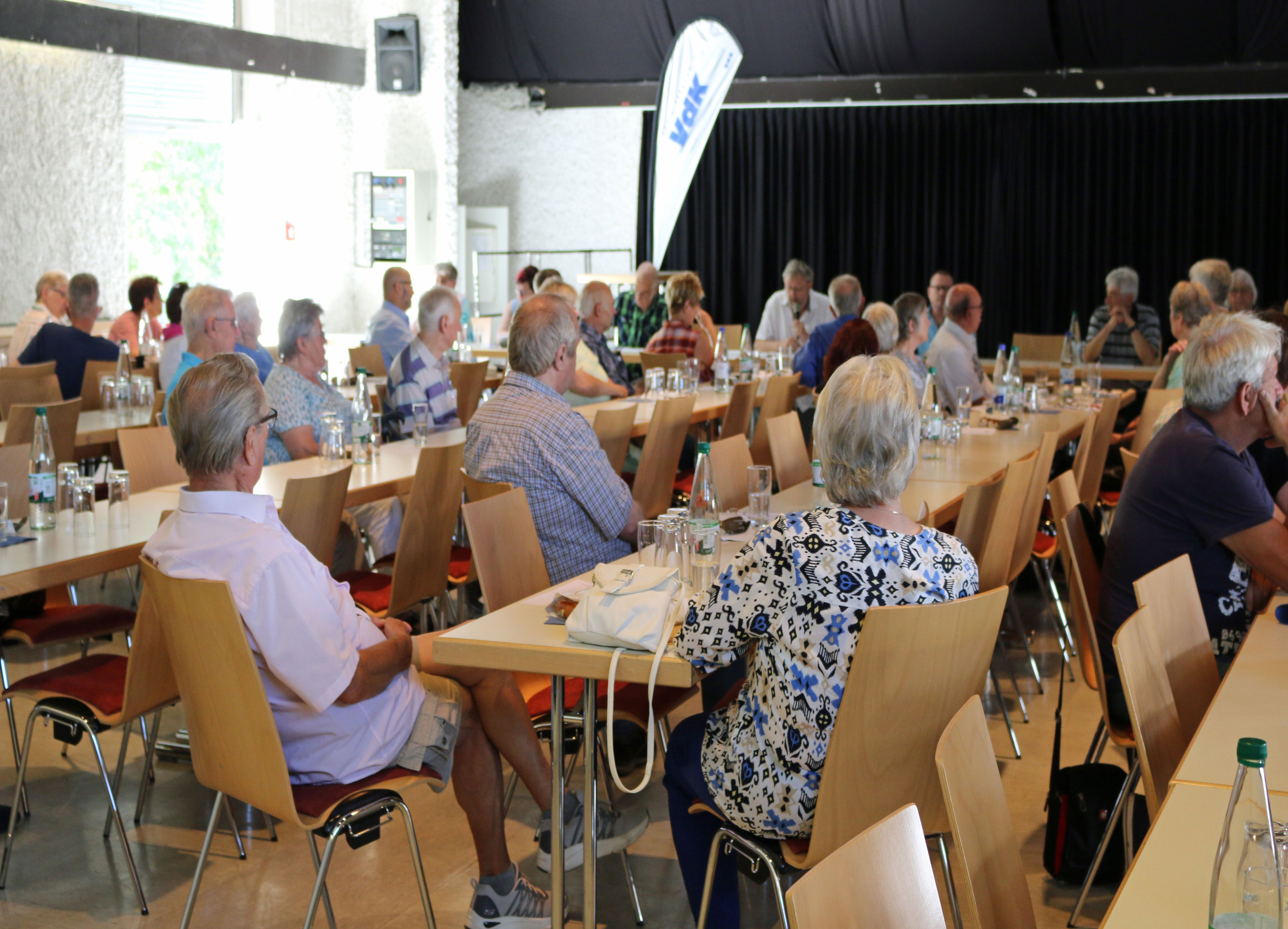 Mitglieder sitzen bei der Jahreshauptversammlung an Tischen im Bürgersaal und hören den Berichten zu