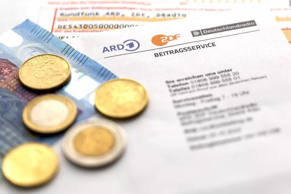 Bild mit Antrag f&uuml;r Rundfunkgeb&uuml;hren mit darauf liegenden Euro-M&uuml;nzen