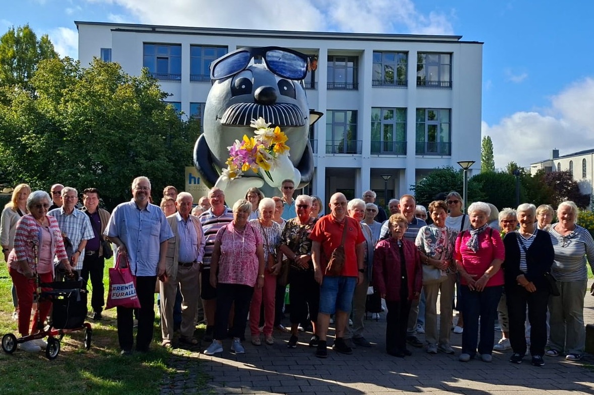 Die Teilnehmer des Ausflugs stehen zum Gruppenfoto vor dem Maskottchen des HR, dem Onkel Otto.
