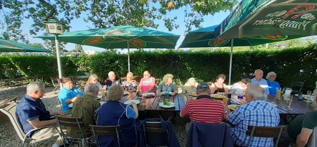 Das Bild zeigt 16 Personen an einem Tisch im Biergraten