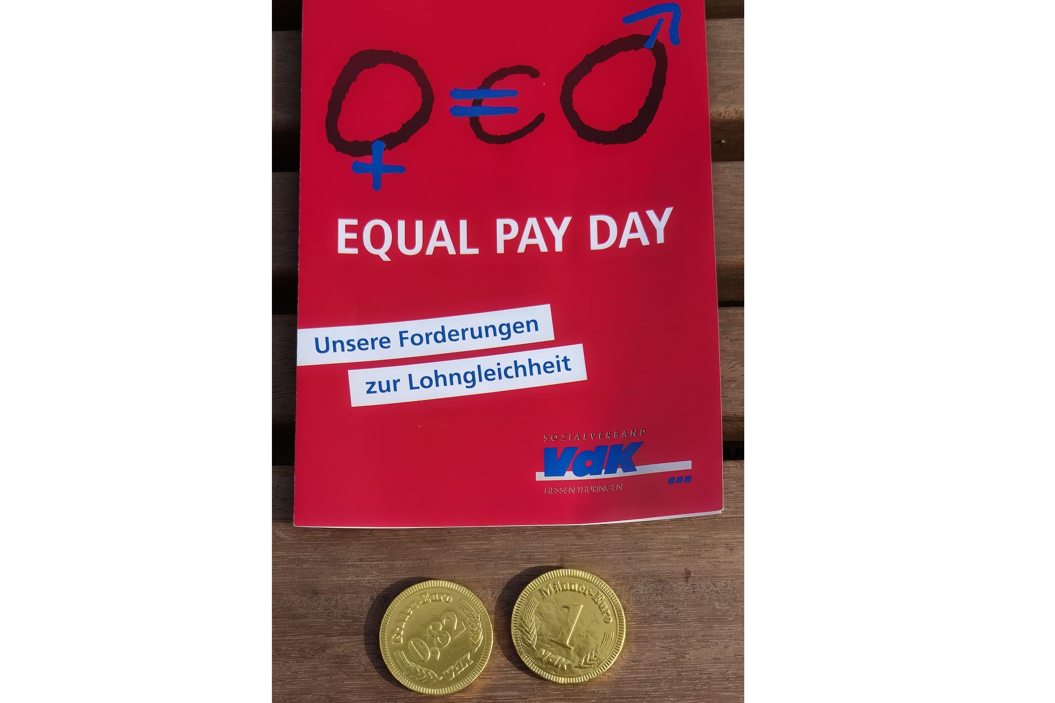 Equal Pay Day 2025 in Wiesbaden Bild einer Broschüre darunter zwei Münzen