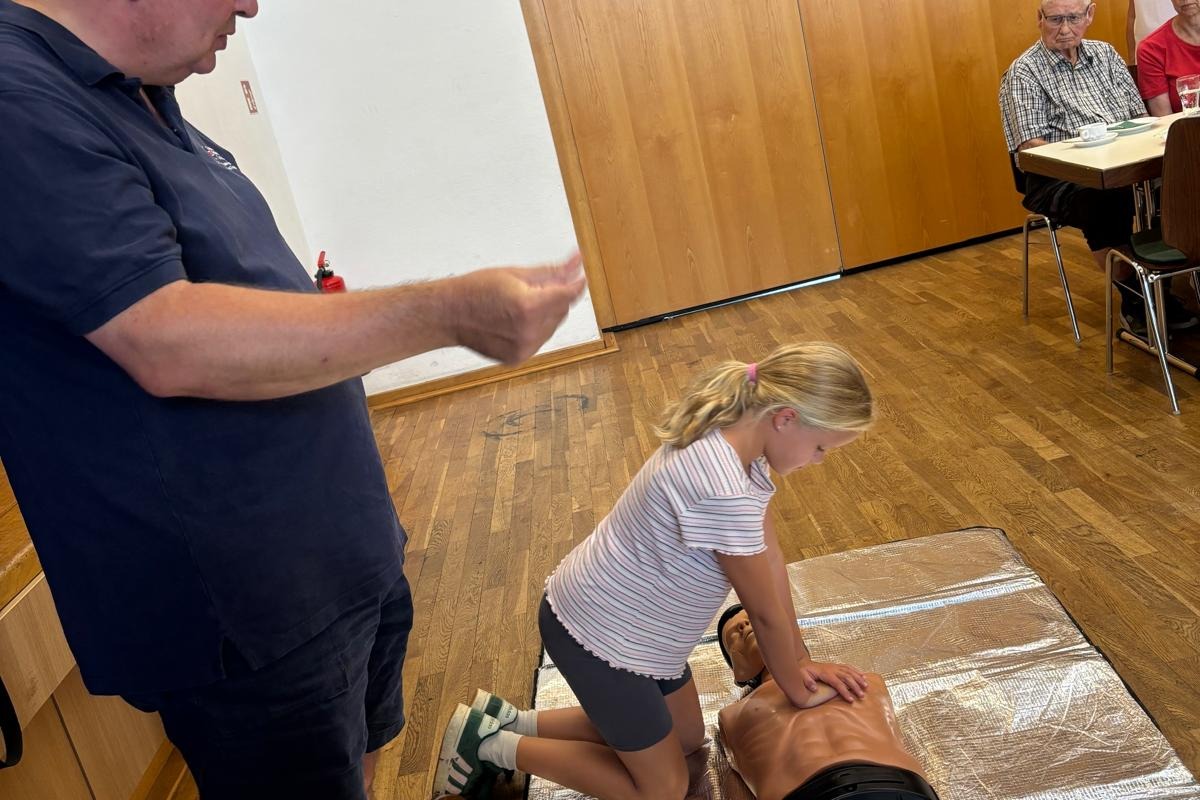Bild zeigt ein M&auml;dchen, dass an einer &Uuml;bungspuppe die Herz-Lungen-Wiederbelebung &uuml;bt