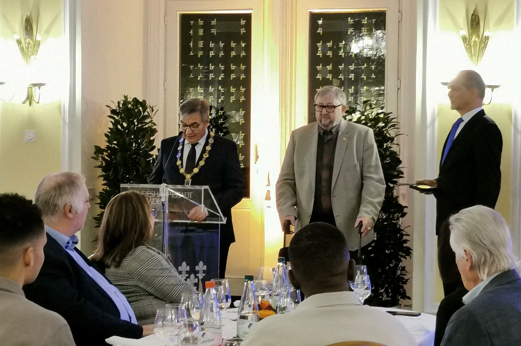 Verleihung der Bürgermedaille an Jürgen Wöhrle Wiesbadens Oberbürgermeister Gert-Uwe Mende steht am Rednerpult und hält die Laudatio. Rechts von ihm stehen Jürgen Wöhrle und StadtverordnetenvorsteherDr. Gerhard Obermayr