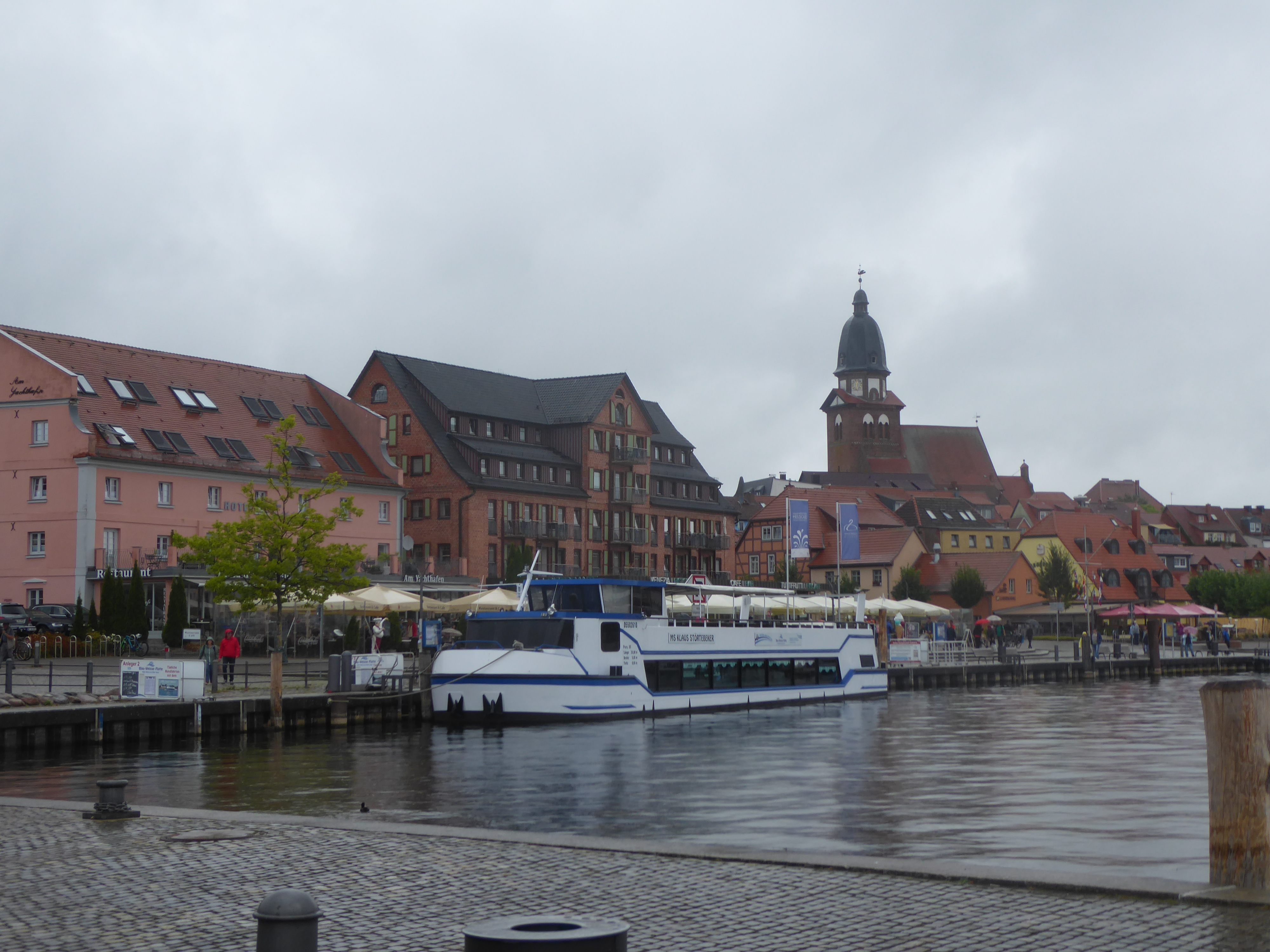 Blick auf den Hafen von Waren mit Schiffen, im Hintergrund Gebäude der Stadt