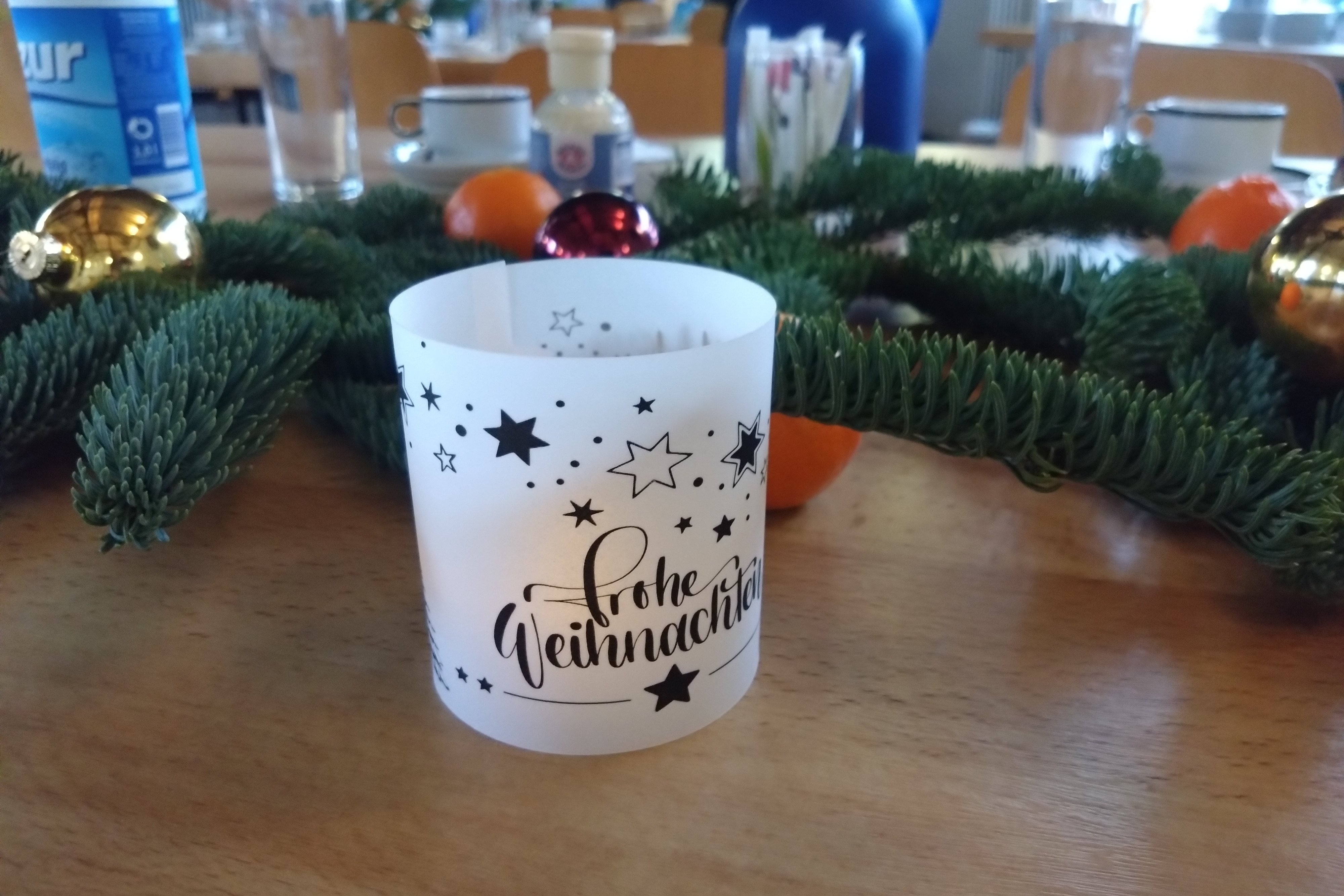 ein weihnachtlich gedeckter tisch mit einem windlicht