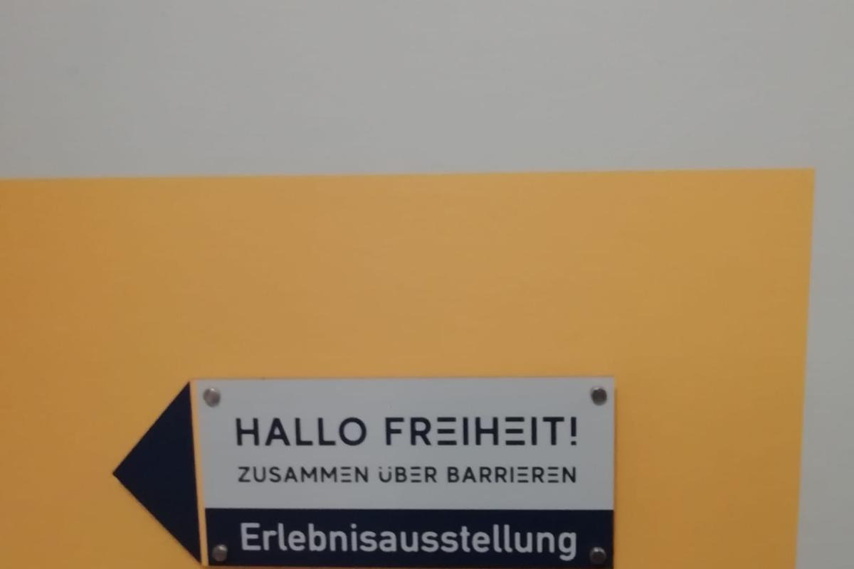 Ausstellungsschild "Hallo Freiheit - Zusammen über Barrieren"