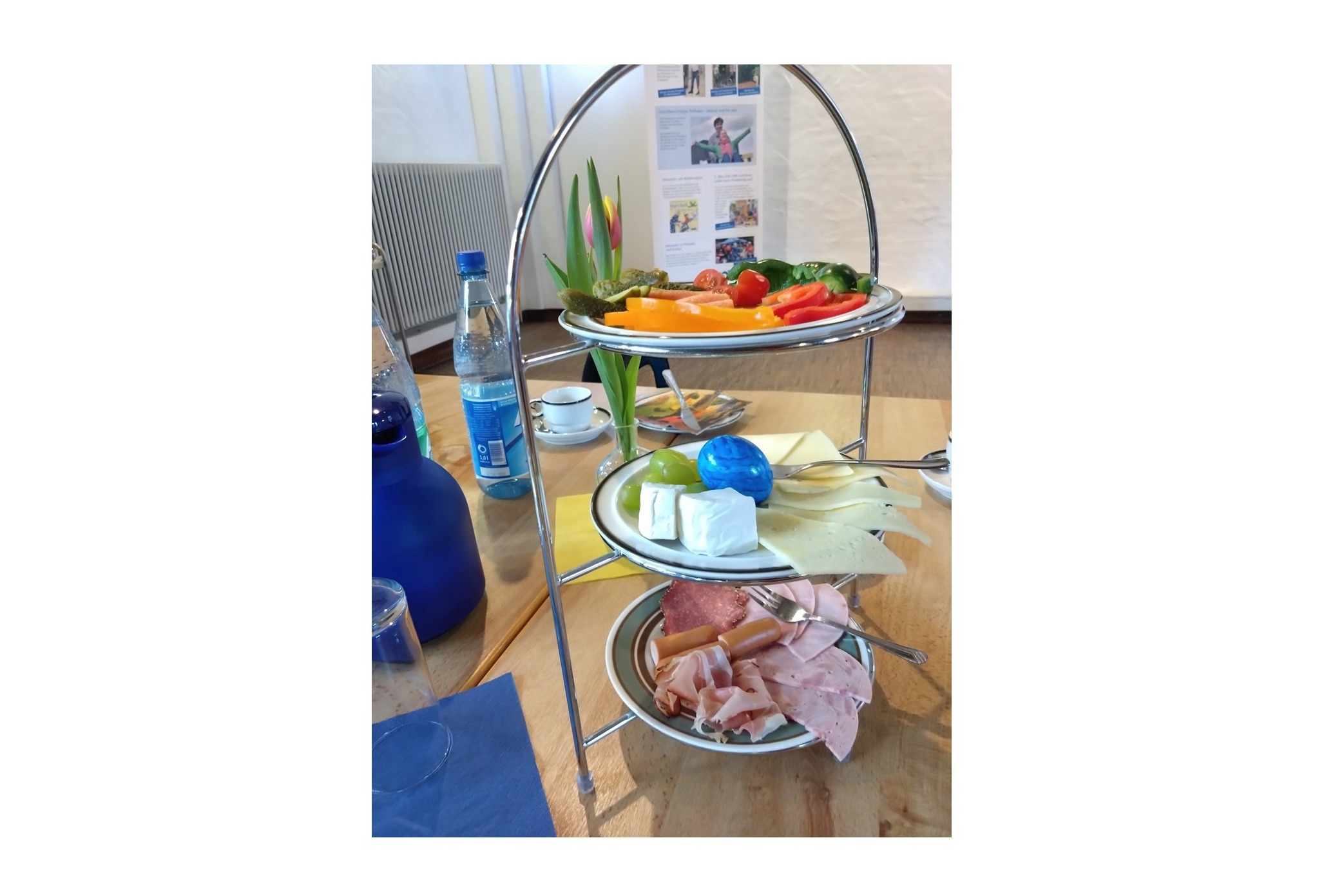 auf einem gedeckten tisch steht eine lecker eingedeckte etagere mit wurst, k&auml;se und gem&uuml;se. im hintergrund ein aufsteller des vdk.